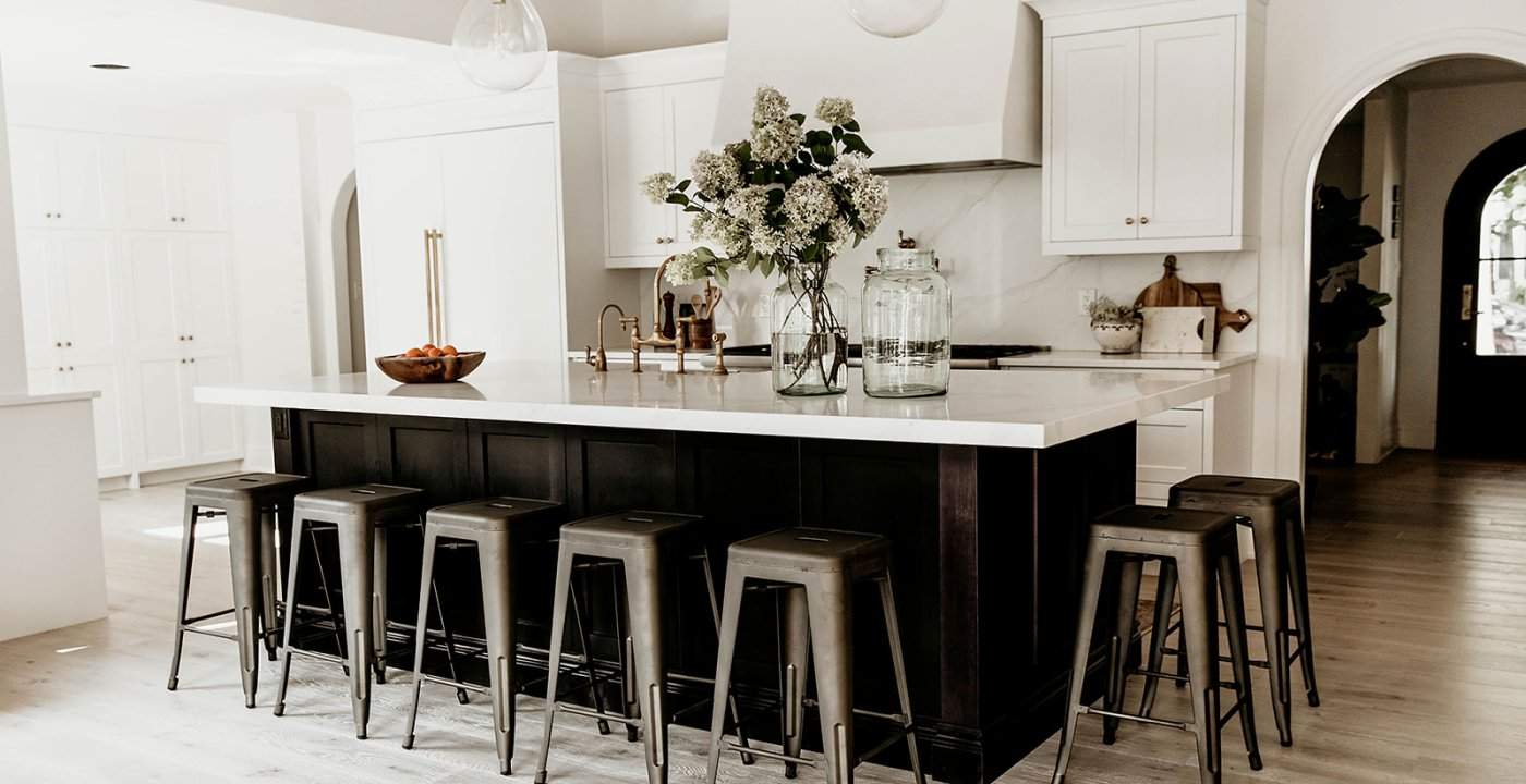 Timeless Kitchen Design With Dark Island, White Shaker Cabinets, And Statement Hood.